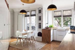 - une cuisine blanche avec une table, des chaises et des fenêtres dans l'établissement 205sm luxury and design flat at Paris Montmartre, à Paris