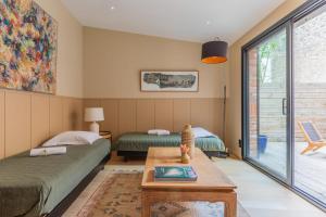 2 Betten in einem Zimmer mit einem Tisch und einem Fenster in der Unterkunft Charming house in Issy-les-Moulineaux - Welkeys in Issy-les-Moulineaux
