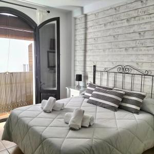 a bedroom with a large white bed with pillows at Dúplex las Terrazas mar y montaña in Vélez de Benaudalla