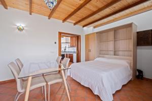 a bedroom with a bed and a table and chairs at Casa El Tarajal in Málaga