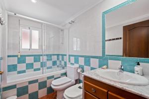 bagno con servizi igienici, lavandino e specchio di Casa El Tarajal a Málaga