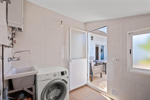 a laundry room with a washing machine and a sink at Casa El Tarajal in Málaga