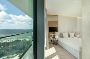 a bedroom with a bed and a view of the ocean at Wave Sea View in Międzyzdroje