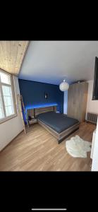 a bedroom with a bed in a blue wall at Chez Anthony in Boulogne-sur-Mer