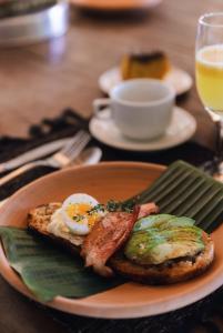 un plato de desayuno con huevos tocino y tostadas en Casa Baiana Pousada & Aconchego en Trancoso