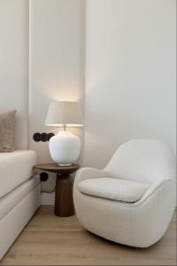 a bedroom with a chair and a lamp on a table at Wave Sea View in Międzyzdroje