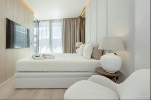 a white bedroom with a bed and a window at Wave Sea View in Międzyzdroje