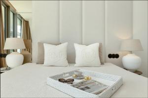 a bed with two pillows and a tray with glasses on it at Wave Sea View in Międzyzdroje