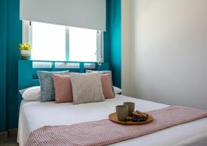 a bedroom with a bed with a tray of food on it at Torremolinos Centro terraza wifi parking ascensor a la playa a 5 min in Torremolinos +29 photos