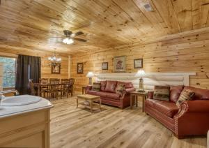 Cabaña de madera con sala de estar con sofás y mesa en Suite Spot #242, en Pigeon Forge