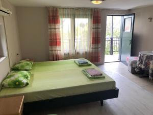 a bedroom with a large green bed in a room at SURF House Villa Rose I Po3a l in Golden Sands
