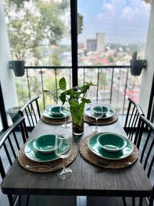 una mesa de madera con platos y vasos en el balcón en Casa 11, en Guatemala