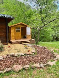 a small wooden cabin in a field with trees at Chalet Vallespir Au fil de l'eau Immersion nature in Lamanère +39 photos