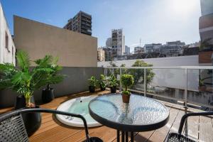 - Balcón con mesa y macetas en un edificio en Fliphaus Bustamante 2400 - 4 Bd Pool Recoleta en Buenos Aires