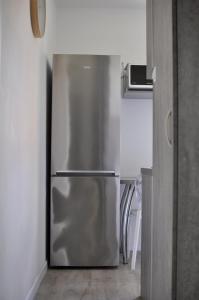 Un refrigerador de acero inoxidable en la esquina de una cocina. en Apartament Verano, en Gdansk