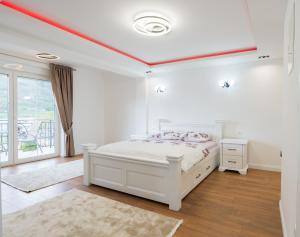 1 dormitorio blanco con 1 cama y techo rojo en Ema Apartments, en Plav