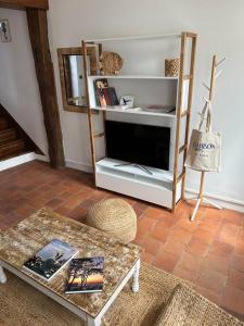 a living room with a tv and a coffee table at Villa Roc Vaudieu - Charmante maison de pêcheurs in Étretat