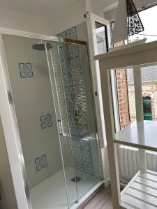 a shower with a glass door in a bathroom at Villa Roc Vaudieu - Charmante maison de pêcheurs in Étretat