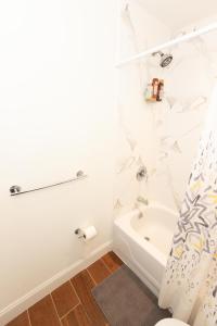 ein weißes Bad mit einer Badewanne und einem WC in der Unterkunft Deluxe Studio Apt Close to NYC in Union City