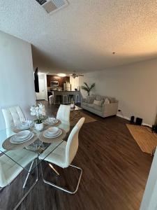 a living room with a glass table and white chairs at Incredible Two Bedroom Hollywood Apartments FREE Parking in Los Angeles