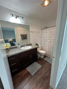 y baño con lavabo, aseo y espejo. en Incredible Two Bedroom Hollywood Apartments FREE Parking, en Los Ángeles