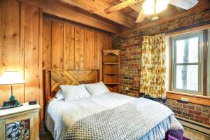 a bedroom with a bed and a brick wall at Treehouse-Style Cabin, 1 Mi to Massanutten Resort in McGaheysville