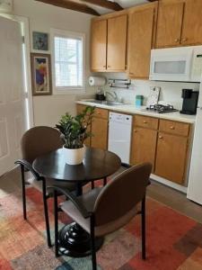 eine Küche mit einem Tisch und Stühlen sowie einem Tisch und einer Küche in der Unterkunft Petite Cajun Cottage Tiny House in Lafayette