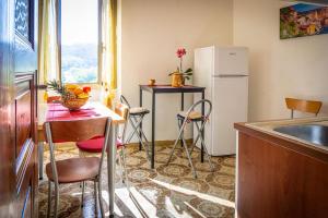 a small kitchen with a table and a refrigerator at Appartamento Middle Earth in La Spezia
