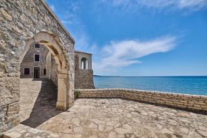 a stone building with the ocean in the background at Apartment Rivarela BLU - newly renovated and top location near sea in Novigrad Istria