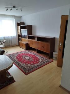 ein Wohnzimmer mit einem Teppich und Holzmöbeln in der Unterkunft Zimmer am Marktplatz Wernberg in Wernberg-Köblitz