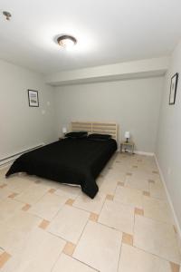 a bedroom with a black bed and a wooden floor at Bright & Cozy 2-Bed Apt mins to NYC in Jersey City