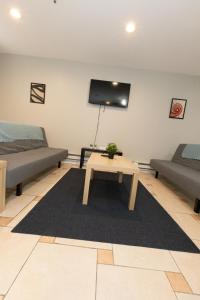 ein Wohnzimmer mit einem Sofa und einem Tisch in der Unterkunft Bright & Cozy 2-Bed Apt mins to NYC in Jersey City