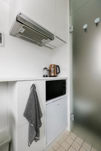 a kitchen with a stove and a microwave at Apartment for one - white in Tallinn