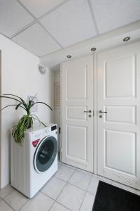 a washing machine in a room with white cabinets at Apartment for one - white in Tallinn