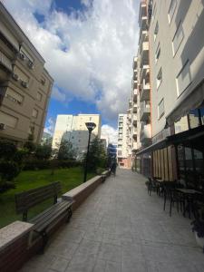 a walkway in a city with benches and buildings at guesthouse apartments in Tirana