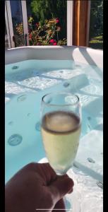una persona sosteniendo una copa de vino en una bañera de hidromasaje en Blue Apart 2, en Puerto Rico