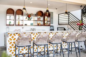 a kitchen with a bar with rattan chairs at The West House Boutique Hotel in San Ignacio