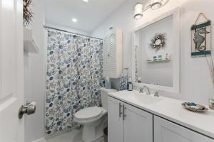 a bathroom with a toilet and a sink and a shower at 5600 Seaview Ave, Unit 15 in Wildwood Crest +8 photos