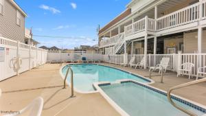 a swimming pool with chairs and a building at 5600 Seaview Ave, Unit 15 in Wildwood Crest