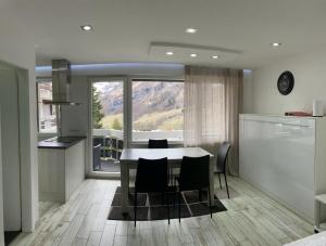 a kitchen and dining room with a table and chairs at Flaminia Wohnung 15 - Best view and Free parking! in Leukerbad