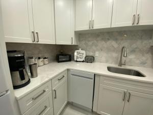 a kitchen with white cabinets and a sink at Closest 1BR to Vanderbilt Beach, full kitchen with dishwasher, ALL NEW! in Naples