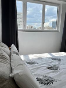 a bedroom with a bed and a window with a view at Confortable et Chic Appartement in Courbevoie
