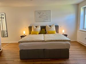 a bedroom with a large bed with yellow pillows at Modernes Studio-Apartment in toller Waldrand-Lage in Kaiserslautern