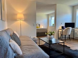 a living room with a couch and a table at Modernes Studio-Apartment in toller Waldrand-Lage in Kaiserslautern