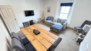 a living room with a wooden table and chairs at Heart of DARTMOUTH TOWN CENTER and with own PRIVATE PARKING - These Two Traditional Georgian SUPER STYLISH DUPLEX APARTMENTS are NEWLY REFURBISHED and have a CONNECTING DOOR For Larger Groups!!! in Dartmouth