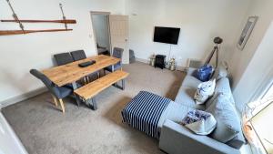 a living room with a wooden table and a couch at Heart of DARTMOUTH TOWN CENTER and with own PRIVATE PARKING - These Two Traditional Georgian SUPER STYLISH DUPLEX APARTMENTS are NEWLY REFURBISHED and have a CONNECTING DOOR For Larger Groups!!! in Dartmouth