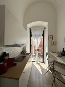 a kitchen with white cabinets and a large window at Casa Garruba 99 in Bari