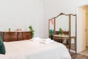 sypialnia z łóżkiem z białą pościelą i lustrem w obiekcie Fliphaus New Ravignani 1600 - 3 Bd Pool Palermo w BuenosAires