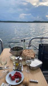 una mesa con comida y vino en un barco en el agua en Hausboot Flying Dragon, en Braunsbedra