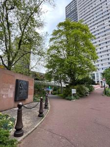 a walkway in a park with trees and buildings at Confortable et Chic Appartement in Courbevoie